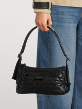 Load image into Gallery viewer, Black quilted handbag held by a person wearing blue jeans on a light gray background