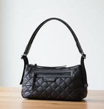 Load image into Gallery viewer, Black quilted handbag with a shoulder strap on a light gray background