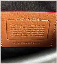 Load image into Gallery viewer, Close-up of a Coach wallet with leather patch and visible branding.