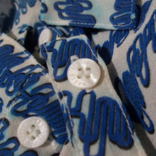 Load image into Gallery viewer, Close-up of a blue and white patterned fabric with buttons.