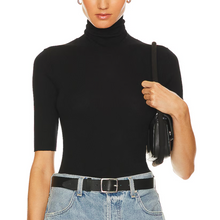 Load image into Gallery viewer, Person wearing a black turtleneck sweater and blue jeans, holding a black handbag on a white background