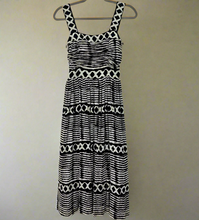 Load image into Gallery viewer, Black and white patterned dress on a hanger against a white background